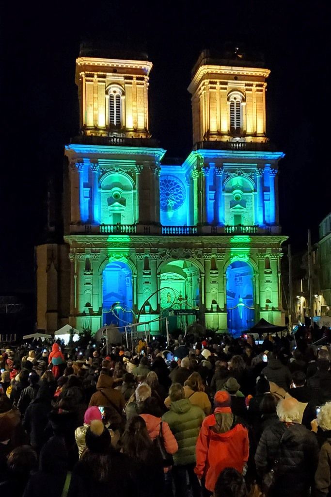 La foule sur le parvis de la cathédrale d'Auch illuminée, qui attend la descente de la Befana